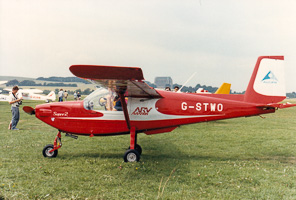 Vintage red airplane at an outdoor aviation event