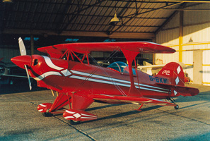 Biplane rests in bright hangar after flight