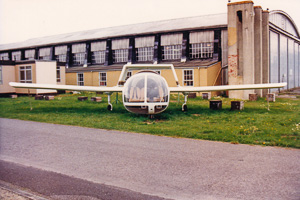 Unique aircraft displayed outside an old hangar