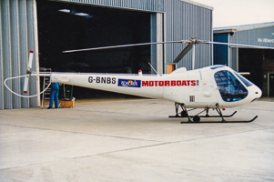 Helicopter parked outside hangar during bright day