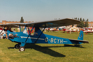 Vintage blue aircraft on a sunny airfield day