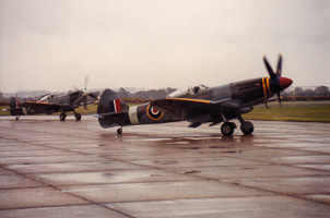 Historic fighters taxiing on a rainy airfield