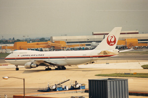 Japan Airlines jet taxiing at a busy airport
