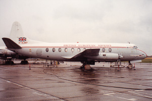 Vintage aircraft perched on a rainy airport tarmac