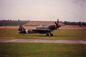 Vintage fighter plane taxis on lush airfield